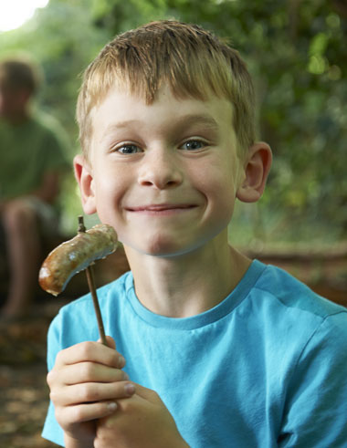 enfant dégustant une chipolata